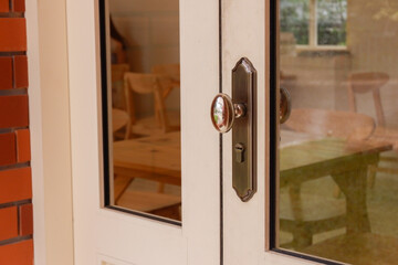 Close up of wooden door with classic golden handles and ornaments,gold door handle and...