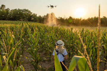 An aerial view of a drone spraying crops, emphasizing the use of technology in modern agriculture...