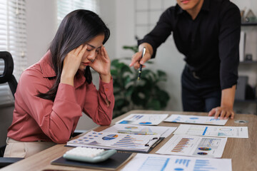 Stressed businesswoman having headache while boss is scolding her at work