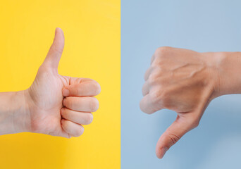 Two hands showing thumbs up and thumbs down gestures. The concept of sign language is like or...