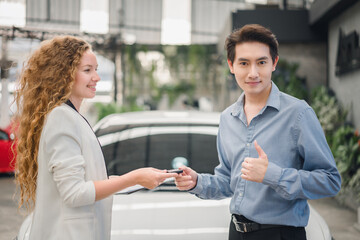 Happy male customer giving thumbs up as dealer hands over keys, showing joy, satisfaction, and trust in successful automotive sales and finance transaction.