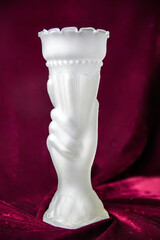 A white vase with a hand on it