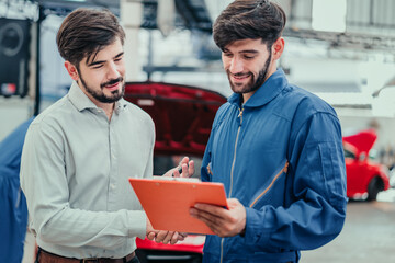 Happy car owner discussing maintenance with mechanic beside red car, representing professional service, trust, and customer satisfaction in automotive repair.