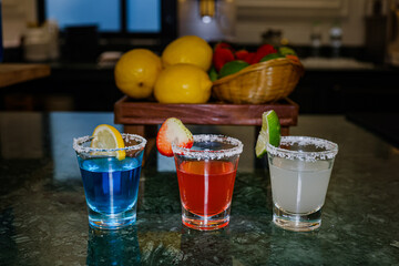 Colorful tequila shots with fruit garnishes and salt rim
