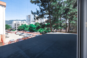 A large window in a building with a view of a city. The window is dirty and the view is obscured by...