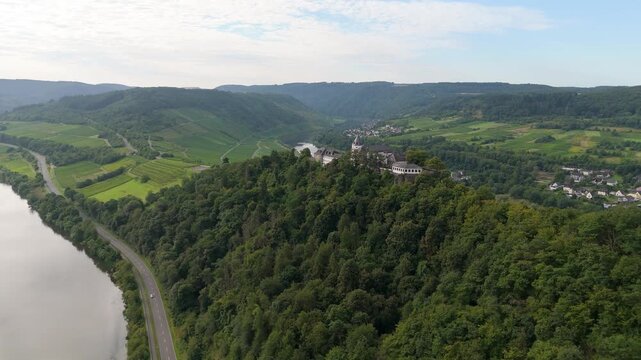 Marienburg castle on Petersberg, aerial panorama view over Moselle valley, vineyards, mountain range of Eifel and Hunsrueck, Mosel river loop near Zell, Germany