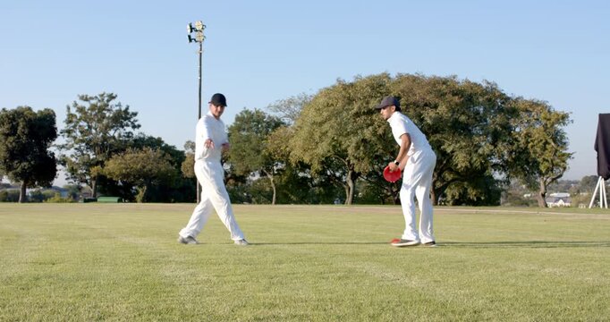 Entering grassy field, diverse male teammates pointing spots, placing red and green cones for drill
