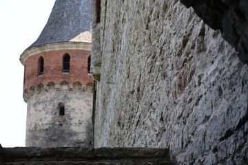 Historic stone wall with a tower in a medieval castle courtyard during daylight hours, showcasing...