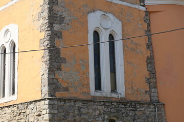 Historic building with peeling paint and stone foundation in a charming town during daylight hours