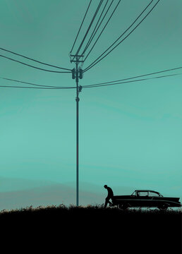 Fototapeta Silhouetted man near vintage car under power lines