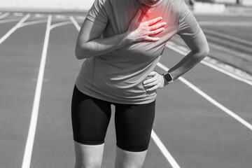 Black and white photo. Injury and pain in the chest of a female runner. A woman suffers from chest...