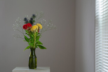 白い部屋に置かれたケイトウとエリンジウムとカスミソウ