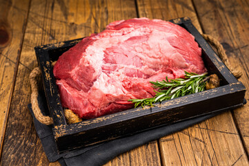 Raw beef boneless shank meat with visible marbling, ready for braising or roasting, offering a flavorful addition to any gourmet dish or family dinner. wooden background. top view