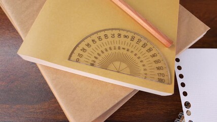 Closeup of protractor ruler measuring tool, pencil isolated on books. - Powered by Adobe