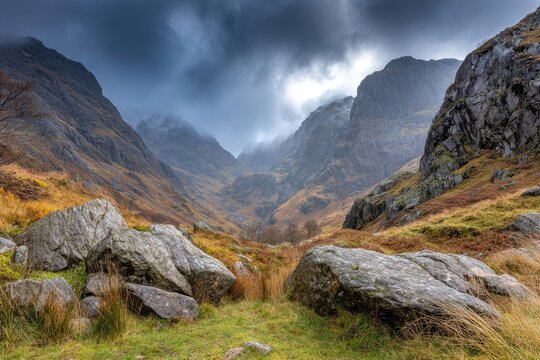 Mountain valley shrouded in autumnal mist, dramatic clouds