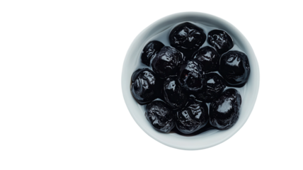 A bowl holds vibrant black olives glistening in natural light, perfect for culinary creations or snacking