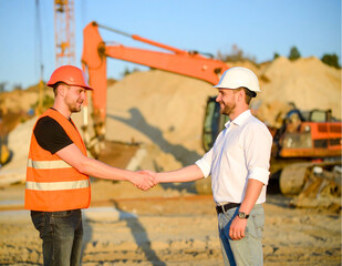 Engineers man handshake at construction site. Workers and construction managers shaking