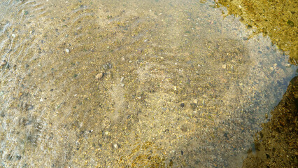Riverbed Sand Particles with Clear Water Reflection