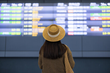 Woman checking flight schedule board at airport