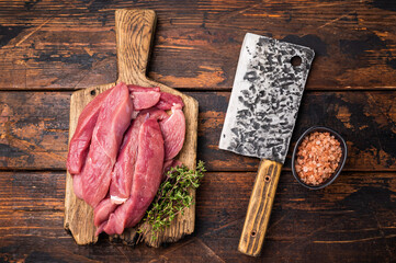 Duck breast fillet, raw sliced poultry meat on butcher board. wooden background. top view
