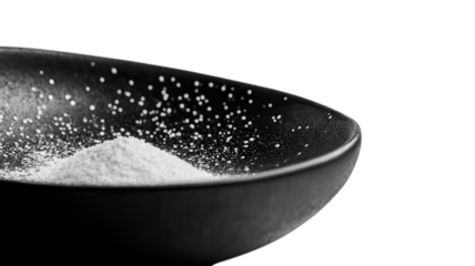 A clear view of a fine powdered substance beautifully displayed in a black dish, highlighting its texture and contrast