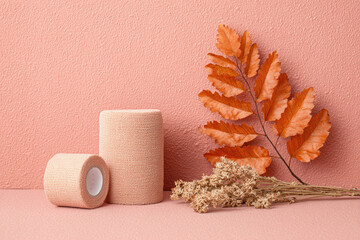 Elastic bandage medical tape autumn leaf dried flower minimal background soft texture healthcare veterinary pastel color calm mood