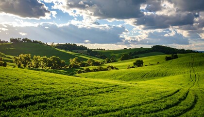 Lush green hills and fields under dramatic sky