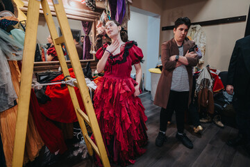 Young performers engage in theatrical preparations backstage, surrounded by vibrant costumes and...