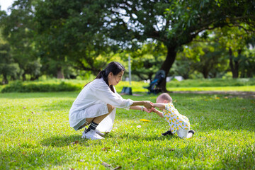Mother holding her baby hand in park