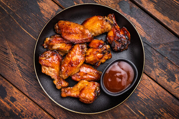 Deliciously sticky teriyakis sauce chicken wings, bursting with flavor, perfect for sharing at festive occasions or family dinners. wooden background. top view