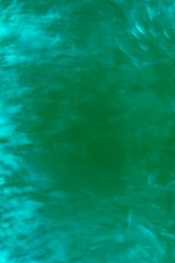 Obraz premium the surface of a body of water, in motion. The water appears subtle ripples and gentle waves creating a textured. The image is soft and slightly out of focus, giving it a dreamy, ethereal quality.