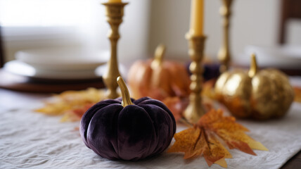 Velvet pumpkin centerpiece with gold candlesticks, autumn leaves, and elegant Thanksgiving table setting