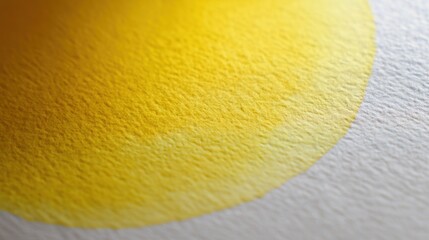 Close-up of a yellow circle on a white surface. the circle appears to be made of a soft, textured material, possibly paper or fabric.