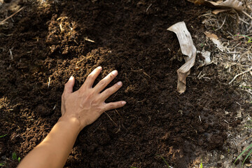 hand touches rich dark mulch. zero waste and circular economy concept for eco friendly lifestyle...
