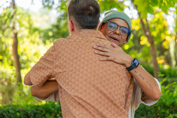 Two Multicultural friends hugging each other in a park