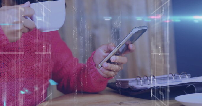 Holding mug, woman in red sweater scrolling smartphone at wooden table, with notebook, copy space