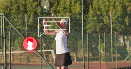 Female athlete wearing sleeveless top and skirt serving on red clay court, with racket and ball