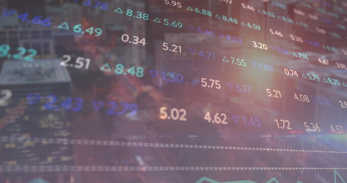 Displaying colored numeric stock data overlaying night city street, with trend arrows and charts