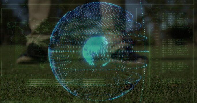 Displaying athlete in black shorts tapping soccer ball on sports field, holographic globe overlay