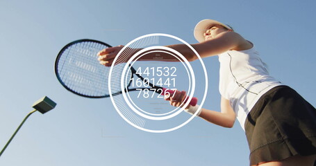 Serving tennis player in white polo black skirt on court, with neon green racket, digital overlay
