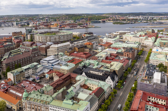 Aerial view of vibrant rooftops contrasting with the shimmering water and industrial cranes near Lilla Bommen and the Gothenburg Opera, Gothenburg, Vastra Gotaland, Sweden.