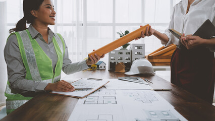 Architects exchanging plans and discussing house project