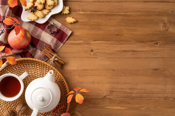Warm autumn tea setup featuring cookies, apple, and leaves, creating a cozy seasonal atmosphere