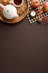 Tea vertical setup featuring a teapot, apples, and cinnamon on a woven tray with autumn decorations