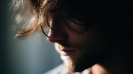 Close-up portrait of a man's face. the man appears to be in his late twenties or early thirties, with long, wavy hair that is blowing in the wind.