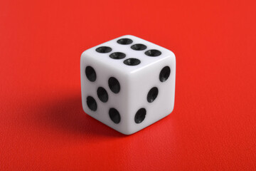 One white dice isolated on red background