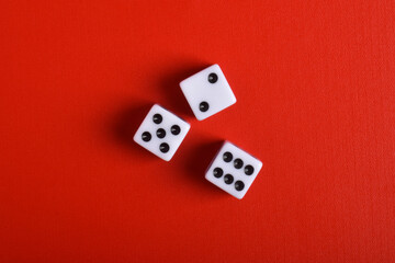 Three dices isolated on red background, top view
