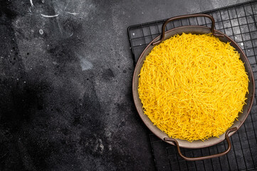 Raw Vermicelli, uncooked pasta in a tray. black background. top view