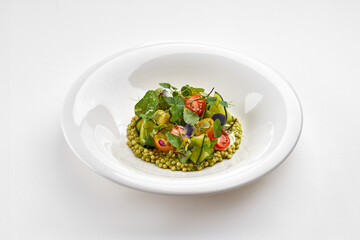 A beautiful gourmet couscous salad with burrata, vibrant cherry tomatoes, cucumber, and microgreens, served in a minimalist white bowl.