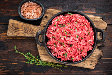 Veal beef raw mince meat, forcemeat in a skillet, on wooden background.